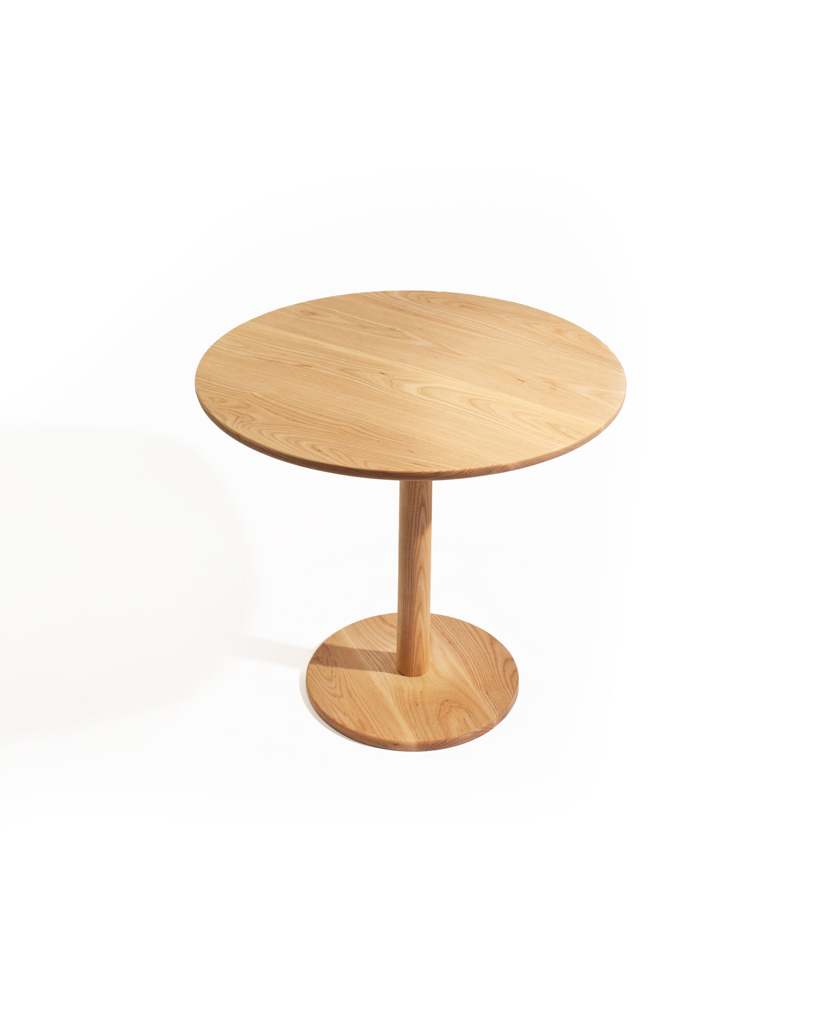 Minimalist solid ash tulip table with round top and sculpted pedestal base